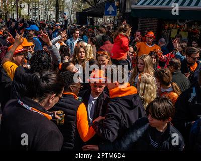 27. April, Amsterdam. Der Königstag ist bekannt für eines der größten und farbenprächtigsten Feste des Landes, insbesondere in Amsterdam. Die Stadt ist voller Orange, während die Menschen die größte Straßenparty des Jahres genießen, die freien Märkte genießen und Spaß auf den Booten entlang der Kanäle haben. Stockfoto