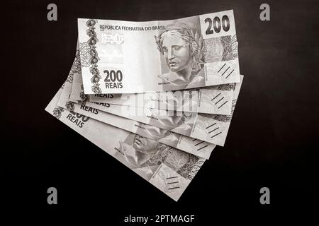 Altes Schwarzweißbild von reich mit Geld in Brasilien. 200 brasilianische Banknoten Reaís Real R$ BRL. Stockfoto