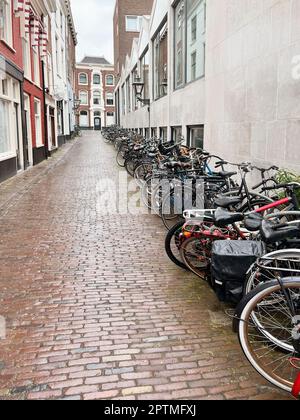 Viele geparkte Fahrräder in der Nähe des Gebäudes an der Stadtstraße Stockfoto