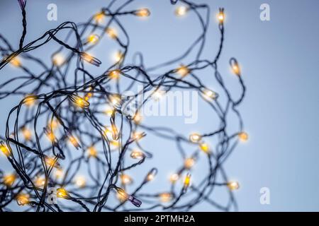 Weihnachtsstimmung. Leuchtendes Festoon mit milden goldenen Lichtern als weihnachtlicher Hintergrund. Neujahrsparty. Moderner Feiertagshintergrund Stockfoto