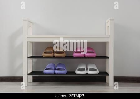 Aufbewahrungsbank mit Paar Gummipantoffeln im Innenbereich Stockfoto