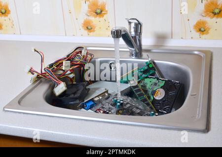 Personal Computer Reinigung metaphorische Konzept. Hardware in der Küche unter Wasser Stockfoto