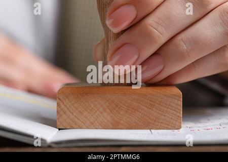 Ukraine, Lemberg - 6. September 2022: Frau stempelt Visumseite im Reisepass am Tisch, Schließung Stockfoto