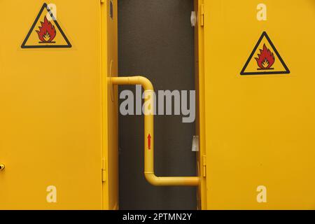 Gelber Gasverteilerschrank in der Nähe der braunen Wand Stockfoto