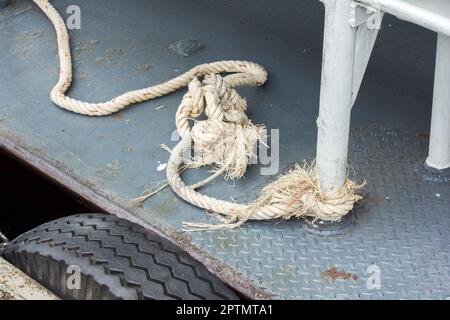 Altes Seil, das an den Stahlmast des Schiffes gebunden ist Stockfoto