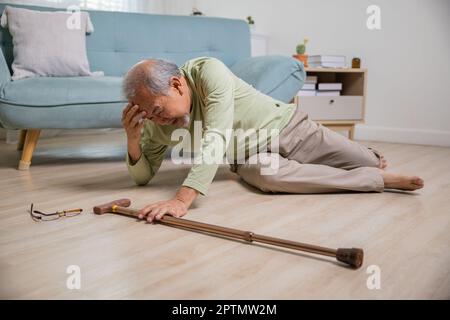 Älterer Senioren Kopfschmerzen, die nach dem Sturz auf dem Boden lagen, Schmerzen und Schmerzen durch Osteoporose, älterer Mann, der allein mit Gehhilfe auf den Boden fällt Stockfoto