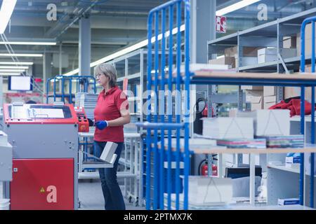 Reife Frau in der Buchdruckindustrie, Bremgarten, Hartheim am Rhein, Baden-Württemberg, Deutschland Stockfoto