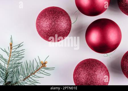 Farbe des Jahres 2023 Viva Magenta. Trendiger Hintergrund für glänzende Weihnachtsbällchen mit weihnachtsbrunch. Modischer Karminton. Speicherplatz kopieren Stockfoto