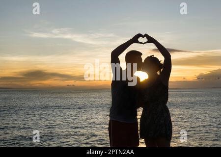 Silhouette eines Paares, das mit Händen ein Herz geformt, Nusa lembongang, Bali, Indonesien Stockfoto