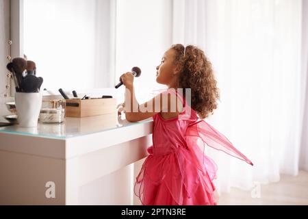 Im gonna Look just like my Mama. A Little girl apping Blusher in den Spiegel Stockfoto