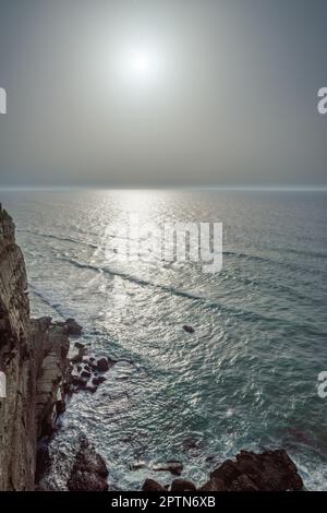 Felsige Küste, Meer und Sonnenlicht scheinen durch Wolkenlücken. Wunderschöner Naturhintergrund. Stockfoto