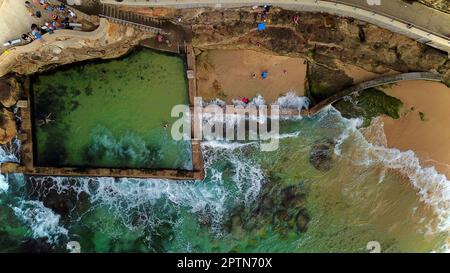 Luftblick auf einen Ozeanpool mit Wellen, die darauf prallen Stockfoto