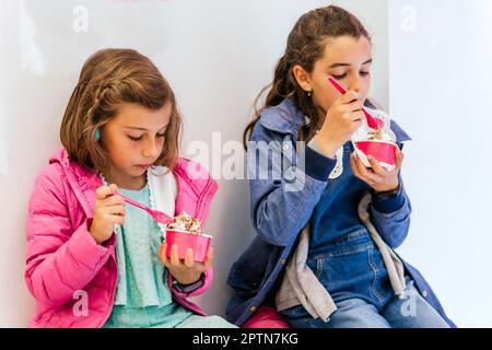 Zwei kleine Mädchen, die Eis essen Stockfoto