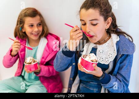 Zwei kleine Mädchen, die Eis essen Stockfoto