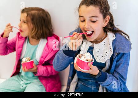 Zwei kleine Mädchen, die Eis essen Stockfoto