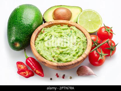 Guacamole-Schüssel und Guacamole-Zutaten isoliert auf weißem Hintergrund. Flach verlegt. Stockfoto