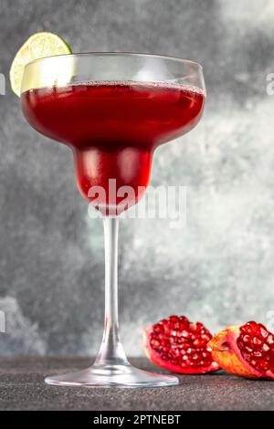 Ein Glas Granatapfel-Margarita-Cocktail auf grauem Hintergrund Stockfoto