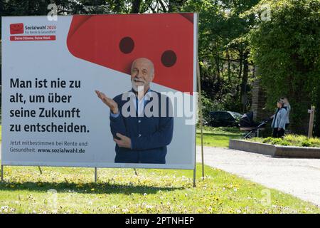 Ein großes Poster als Wahlaufruf für die Sozialwahlen 2023 am 31. Mai 2023 ist auf einer belebten Straße, im Hintergrund laufen zwei Frauen mit Kinderwagen, Die Sozialwahlen bzw. die Sozialversicherungswahlen sind die Wahl in die Selbstverwaltungsorgane der gesetzlichen Sozialversicherungsträger in Deutschland. Sie findet alle sechs Jahre bei allen gesetzlichen Renten-, Kranken- und Unfallversicherungen statt. Oberhausen, 27. April 2023 Stockfoto