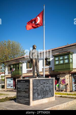 Eine Bronzestatue von Mustafa Kamal Atatürk, dem Gründer der modernen Türkei, steht auf einem großen Granitsockel neben einem Fahnenmast, in dem die türkische Flagge fliegt Stockfoto