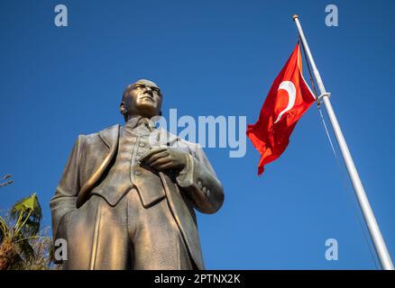 Eine große Bronzestatue von Mustafa Kamal Atatürk, dem Gründer der modernen Türkei, steht neben einem Fahnenmast, der auf einem Platz in Side Ol die türkische Flagge fliegt Stockfoto