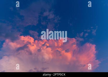 Purpurfarbener Himmel in der Dämmerung am Abend, dunkler Hintergrund am Himmel. Farbenfroher Himmel. Abendhintergrund. Dramatischer Sonnenaufgang, Sonnenuntergang, rosa violett blauer Himmel mit Cirru Stockfoto