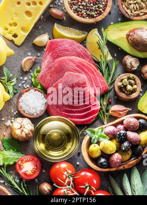 Rohe Thunfischsteaks mit Gewürzen und Gemüse auf dem Graphitbrett. Mediterrane Küche. Draufsicht. Stockfoto