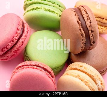 Bunte französische Makronen isoliert auf pinkfarbenem Hintergrund. Stockfoto