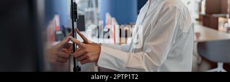 Lächelnde Frau, die ein Passwort oder einen PIN-Code eingibt, um die Sicherheitstür im Büro zu öffnen und zu öffnen Stockfoto