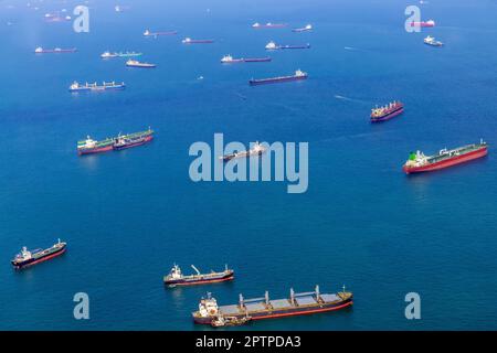 Luftaufnahme der Warteschlangen von Frachtschiffen, die in den Hafen von Singapur, Singapur, einlaufen. Stockfoto