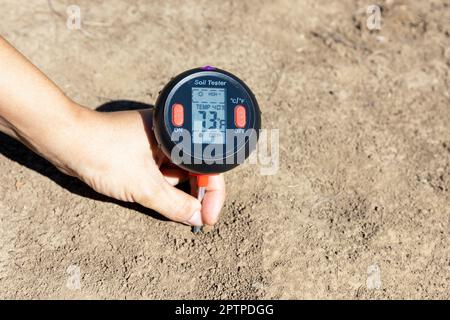 Messung der Temperatur in der fahrenheit-Skala, des Feuchtigkeitsgehalts des Bodens, der Umgebungsfeuchte und der Beleuchtung. Konzept der globalen Erwärmung. Stockfoto