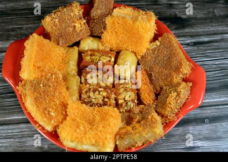 Traditionelle arabische und türkische Desserts, östliche Süßigkeiten Baklava-Auswahl mit Pistazien, Basbousa und süßem Dessertgebäck, Konafa mit Nüssen und cr Stockfoto