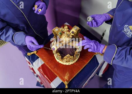 Die Cadbury World Chocolatiers Dawn Jenks und Donna Oluban verleihen der Cadbury World in Birmingham, einer 45cm m hohen Schokoladenreproduktion der St. Edward's Crown, den letzten Schliff. Es dauerte zwei Tage, um ihre Version der Krone zu bauen, die bei der Krönung von König Karl III. Mit weißer Schokolade und Milchschokolade verwendet und mit essbarem Glitzer bestaubt wird. Bilddatum: Mittwoch, 26. April 2023. Stockfoto