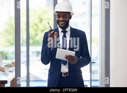 Black man, Tablet und Walkie-Talkie im Baumanagement, im Bürogebäudeplan oder in der Architekturplanung. Lächeln, glücklicher Ingenieur Stockfoto