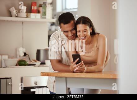 Glückliches, verliebtes Paar mit einem Telefon, das sich lustige Inhalte in sozialen Medien ansieht, Videos ansieht oder online in Verbindung bleibt. Verbundenheit, Romantiker und Wom Stockfoto