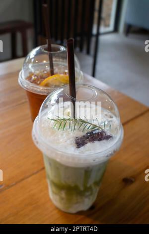 Grüner Eistee mit Milch und Zitronentee auf Holztisch, Stockfoto Stockfoto