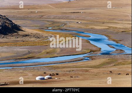 Ein Jurtenlager mongolischer Nomaden an einer Flussbiegung in der Steppe der Mongolei in Zentralasien Stockfoto