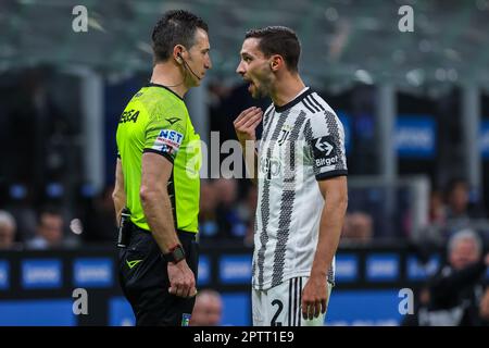 Mailand, Italien. 26. April 2023. Mattia De Sciglio vom FC Juventus (R) und Schiedsrichter Daniele Doveri (L) beim Halbfinale 2022/23 des Fußballspiels Coppa Italia 2. Leg zwischen dem FC Internazionale und dem FC Juventus im Giuseppe Meazza Stadion. Endstand: Inter 1:0 Juventus. Kredit: SOPA Images Limited/Alamy Live News Stockfoto