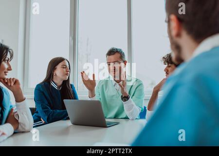 Eine Gruppe von multiethnischen medizinischen Fachkräften, darunter Ärzte, Chirurgen und Krankenschwestern, sind in einem Krankenhaus zusammengekommen, um die Patientenversorgung und zu diskutieren Stockfoto