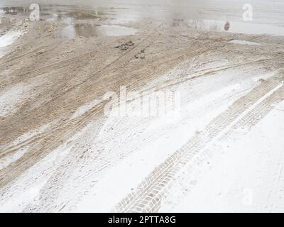 Eine Gabel oder ein Schild aus einem Kreisverkehr. Schneeverwehungen am Straßenrand. Schlechtes Wetter und Verkehr. Schnee auf Asphalt. Schwierige Fahrbedingungen. Im Winter Stockfoto