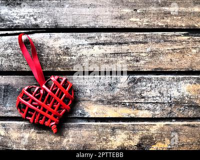 Ich liebe rotes Korbherz mit Holzstruktur. Valentinstag-Grußkarte. Draufsicht mit Kopierbereich. Rotes Korbherz aus Zweigen oder Stroh. F Stockfoto