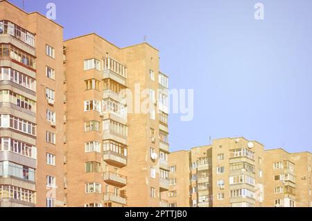 Detaillierte Foto von mehrstöckigen Wohnhaus mit vielen Balkonen und Fenstern. Herbergen für die armen Menschen in Russland und der Ukraine in einem beschädigten con Stockfoto