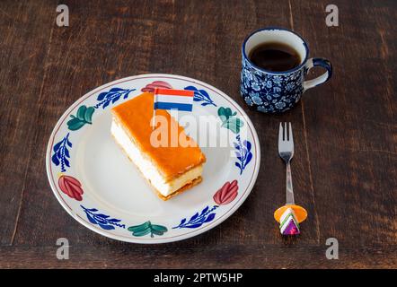 Traditionelles holländisches Gebäck namens Tompouce mit orangefarbener Oberseite und holländischer Flagge, das in der Regel während der Feierlichkeiten zum Königstag gegessen wird Stockfoto