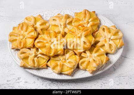 Gebackene Ananas in Blätterteig auf hellgrau-blauem Hintergrund, Draufsicht. Köstliche hausgemachte Puffs Stockfoto