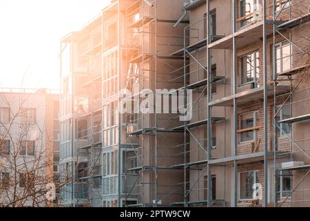 Die Installation von Wärmedämmung für Außenwände. Passive Außenwand-Wärmedämmung der Hauswand. Isolierfassade eines mehrstöckigen Wohngebäudes. Stockfoto