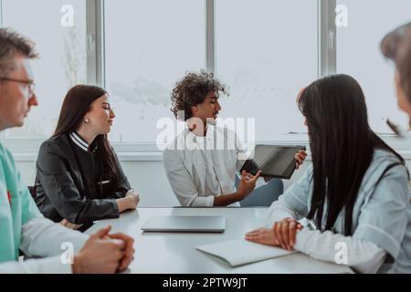 Eine Gruppe von multiethnischen medizinischen Fachkräften, darunter Ärzte, Chirurgen und Krankenschwestern, sind in einem Krankenhaus zusammengekommen, um die Patientenversorgung und zu diskutieren Stockfoto
