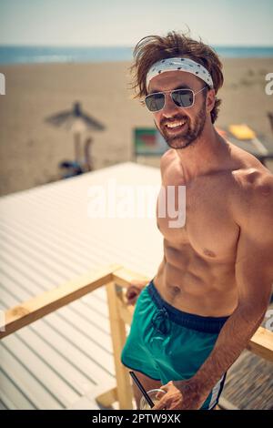 Attraktiver junger Mann am Strand, der den Sommerurlaub genießt Stockfoto