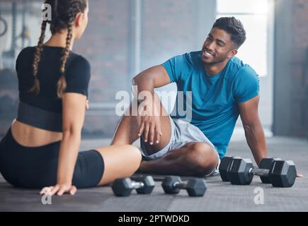 Glückliches Paar, Fitness und Bewegung mit Personal Trainer und Kunde sprechen über Wellness, Gesundheit und Workout-Plan auf dem Fitness-Studio Boden. Glücklicher indischer Mann und Stockfoto