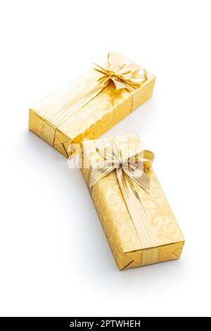 Geschenk in Goldfolie verpackt. Weihnachtsgeschenk mit Goldband isoliert auf dem weißen Hintergrund.