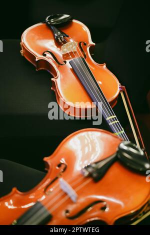 Detailansicht von zwei Violinen auf einigen Stühlen. Stockfoto