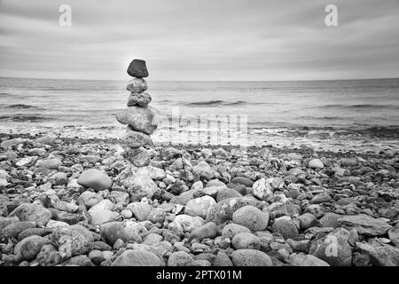 Steinpyramide am Strand mit Blick auf das Meer. Dänische Küste. Skandinavisches Landschaftsfoto Stockfoto